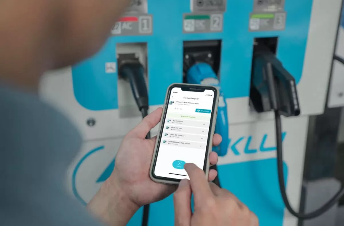 Ilustrasi pengguna EV sedang menggunakan aplikasi PLN Mobile untuk mengisi daya di salah satu SPKLU.
