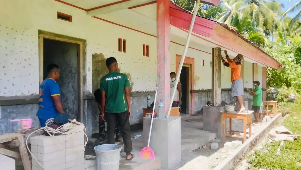 Babinsa Koramil 04/Rainis bersama anggota satgas dan warga bergotong royong dalam program karya bakti renovasi gedung SMK-7 Dapihe, Kabupaten Kepulauan Talaud.  ((Foto: Dok. Istimewa))