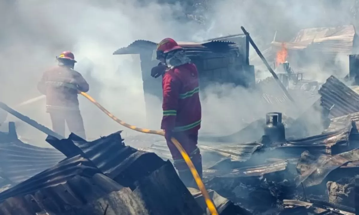 PETUGAS DAMKAR PADAMKAN SISA API DI LOKASI KEBAKARAN. 