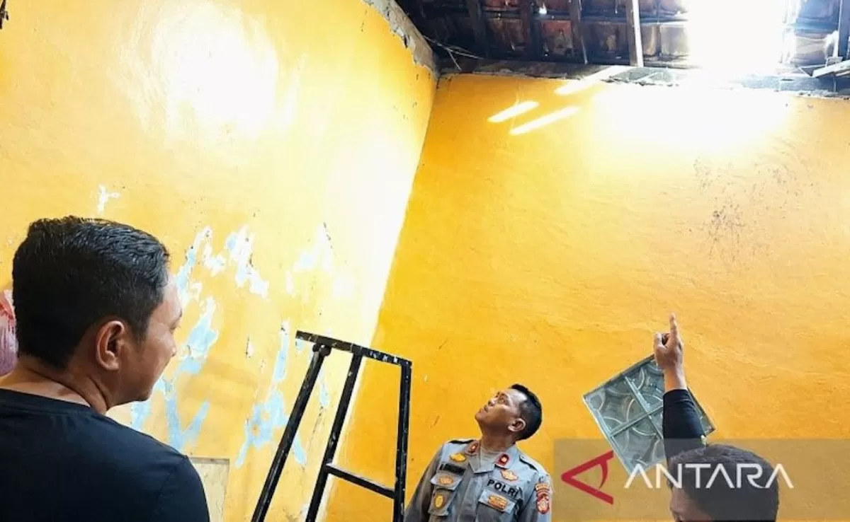 Warga menunjukkan kepada polisi genteng rumah milik seorang ibu rumah tangga yang dijebol pelaku pencurian barang berharga di Karawang.  (ANTARA/Ali Khumaini)
