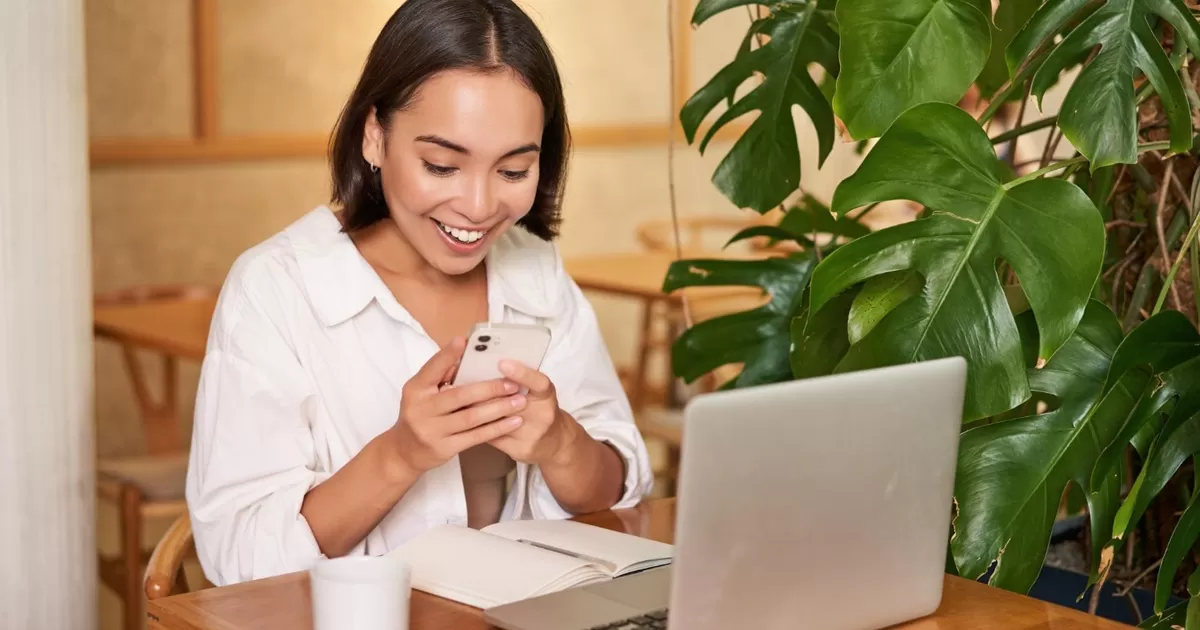 Ilustrasi: Lagi kerja, senyum-senyum sendiri baca chat dari bestie. Gimana sih cara menahan diri untuk nggak terus-terusan scrolling handphone saat lagi kerja? (Freepik/Benzoix)