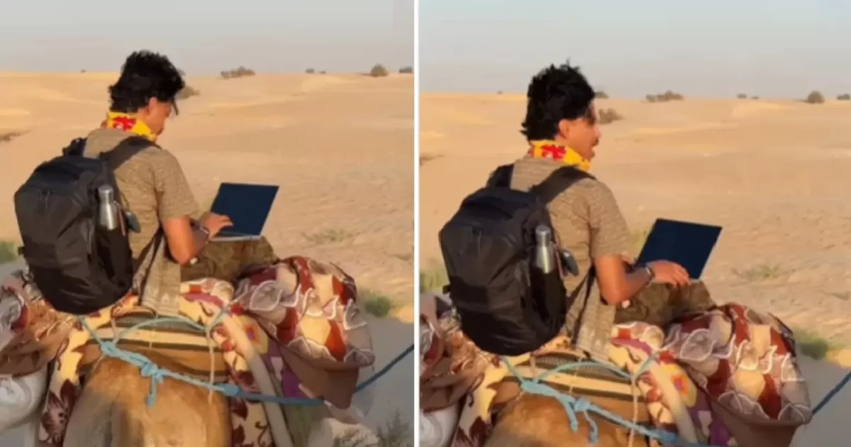 Seorang pria terekam sedang naik onta di Gurun Sahara sambil buka laptop. (Instagram @sodakhtar)