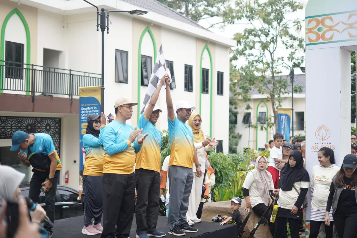 Pembina Yayasan Ar-Rois Cendekia, Abdul Rouf Mahfudz (baju biru kuning sebelah kanan) mengibarkan bendera berlangsungnya fun walk di Ar-Rois Kota Semarang, Minggu (15/2/2026). (Istimewa for Pantura Network)