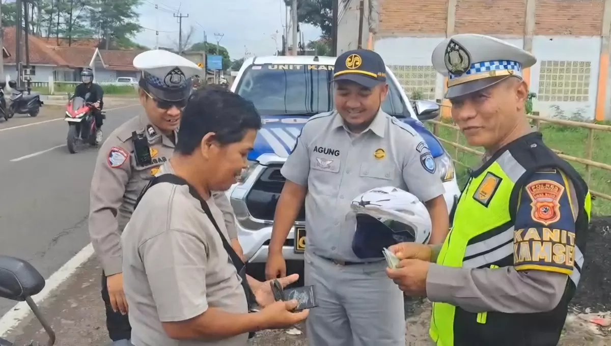 Kanit Kamsel Satlantas Polres Subang, Ipda Sukendar (kanan) bersama Jasa Raharja memberikan helm gratis kepada pengendara dalam edukasi keselamatan berlalu lintas di Jalan Raya Subang Cibogo, Senin 25 Mei 2026