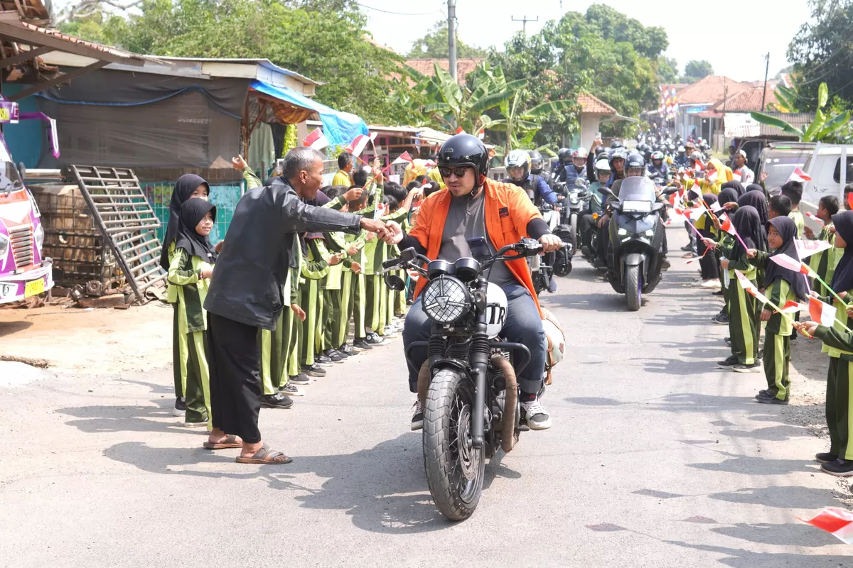 Bupati Subang Reynaldy Putra Andita Budi Raemi (Kang Rey) menyapa warga saat melintas di Desa Kihiyang, Kecamatan Binong. Disambut antusias pelajar yang berbaris sambil mengibarkan bendera merah putih. Kamis, 16 Juli 2026 (Dok. Istimewa)