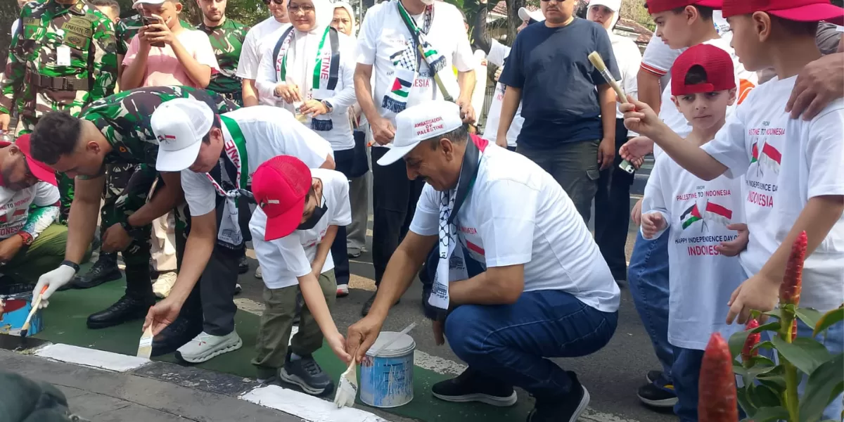 Duta Besar Palestina untuk Indonesia, Abdalfatah A.K. Alsattari bersama staf Kedubes Palestina untuk Indonesia mengecat pembatas jalan dalam rangka menyambut HUT RI ke-81. (Ragil Firdaus/Senayan Post)