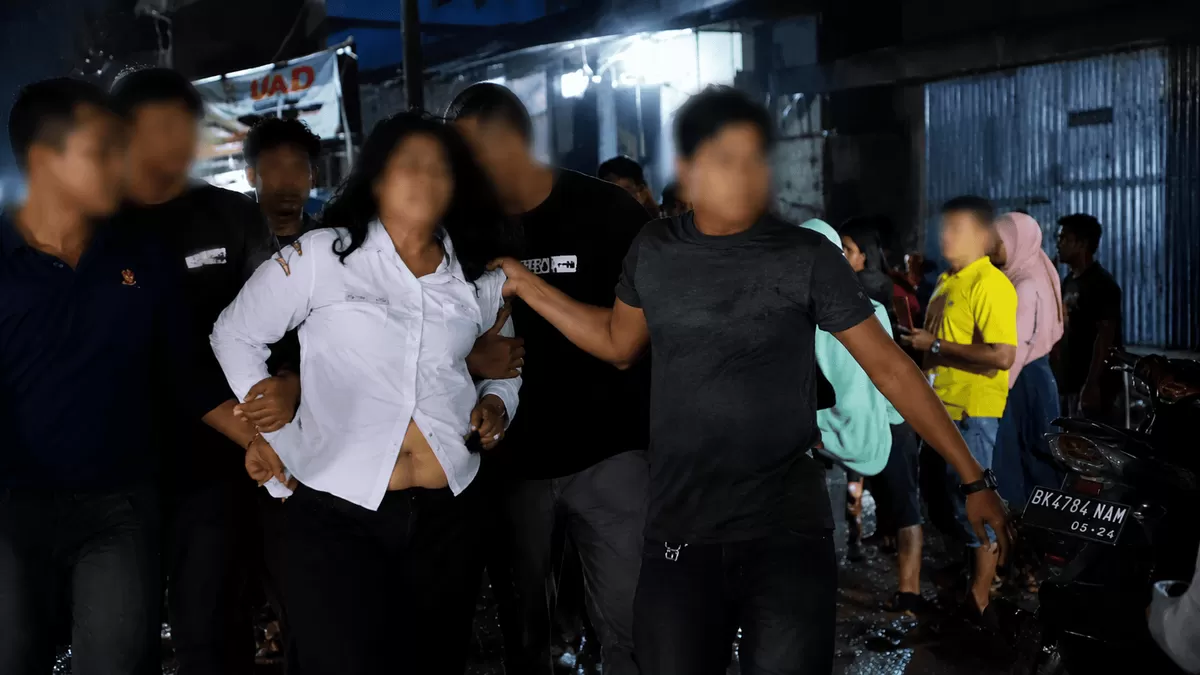 Petugas mengamankan terduga pelaku kasus dugaan kekerasan seksual terhadap anak di Tanjungbalai dengan wajah diburamkan saat dievakuasi dari lokasi kejadian.