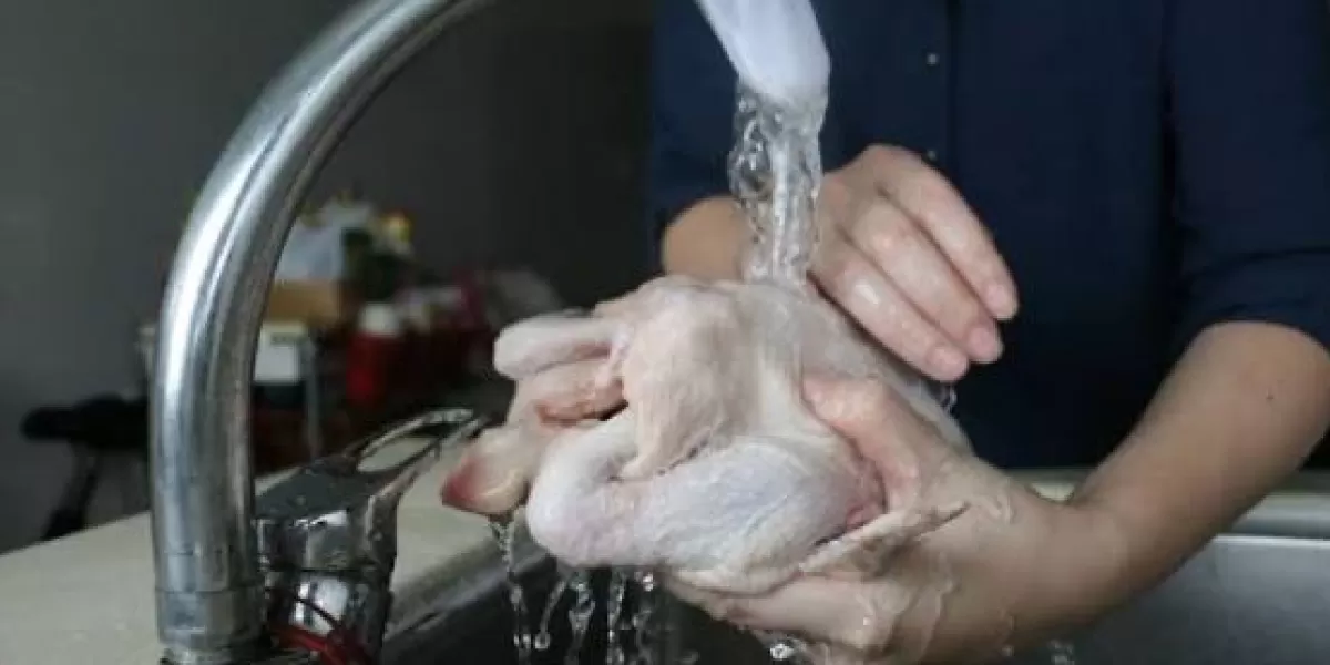 Ilustrasi mencuci ayam mentah di bawah air mengalir yang berpotensi menyebarkan bakteri ke berbagai permukaan dapur.  (X/AymanAlatas)