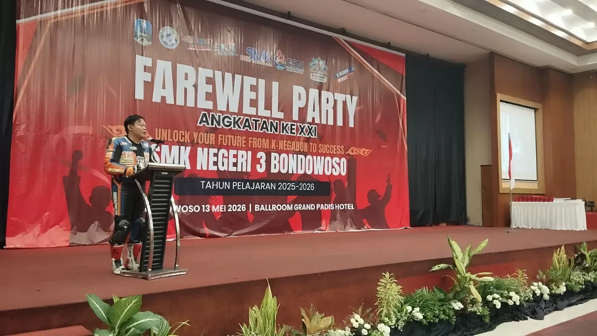 Kasek SMKN 3 Bondowoso Daris Wibisono Setiawan menyampaikan sambutan di acara wisuda dengan mengenakan pakaian balap motor lengkap. (SketsaNusantara.id/As ad Choirudin)