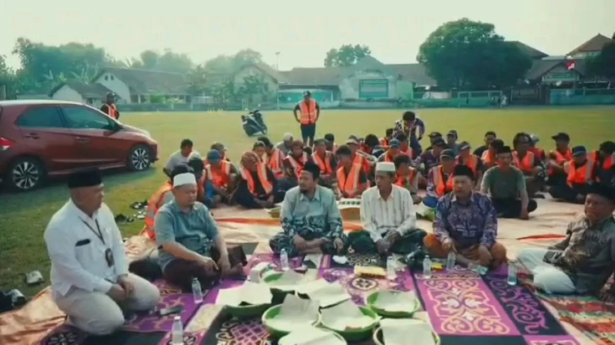 Ketua Umum Yayasan PPBU Tambakberas, KH Abdurrozaq Sholeh bersama para pekerja sedang melakukan doa bersama. (Muhammad Haris Firdaus/SketsaNusantara.id)