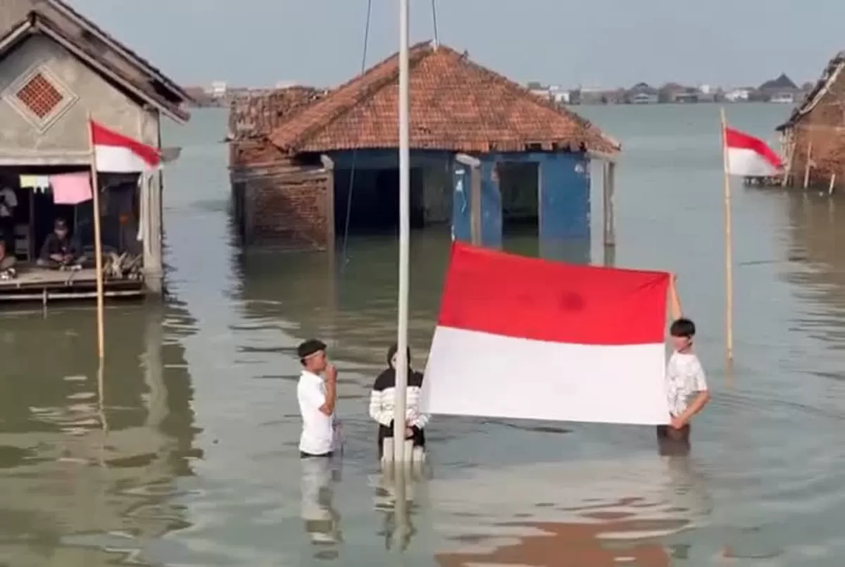 Warga Timbulsloko Demak menggelar upacara HUT ke-81 RI di tengah banjir rob pada Senin (17/8/2026) demi menyuarakan ancaman krisis iklim.