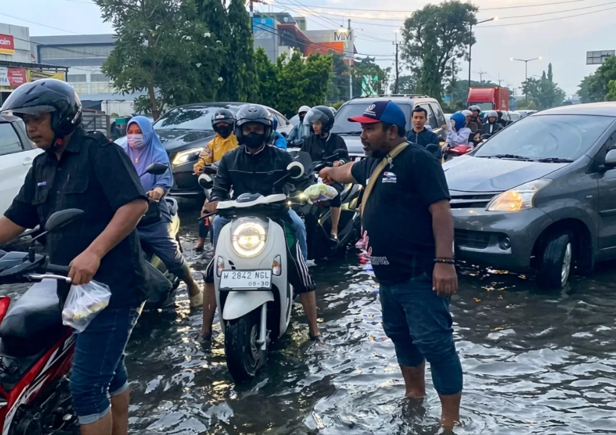 Tim MAKI Jatim membagikan takjil kepada pengguna jalan di By Pass Juanda meski hujan deras. (Nawi)