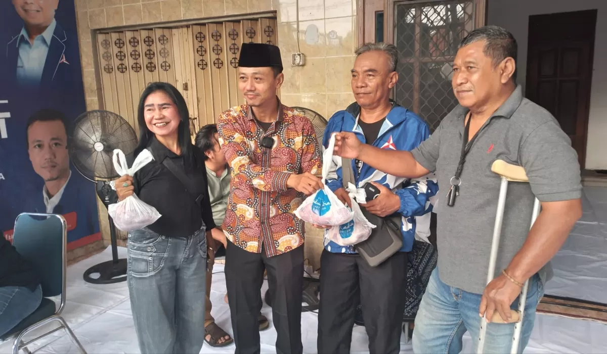 Sekretaris DPC Partai Demokrat Surabaya, H. Junaedi (kedua dari kiri) saat membagikan daging kurban kepada perwakilan masyarakat. 