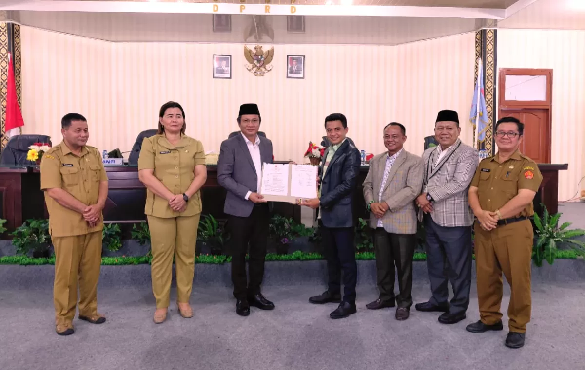Bupati Nias Barat Eliyunus Waruwu dan Ketua DPRD Kevin K.P. Waruwu menunjukkan Nota Kesepakatan Perubahan KUA-PPAS APBD 2026 usai rapat paripurna, Senin (28/9/2026).