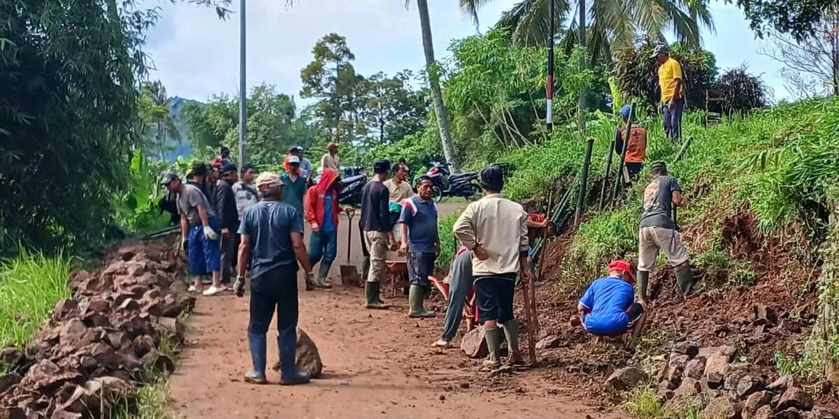 Warga Setempat Gotongroyong Bersihkan Material longsoran yang menutup setengah badan jalan. (Selamet Riyadi)