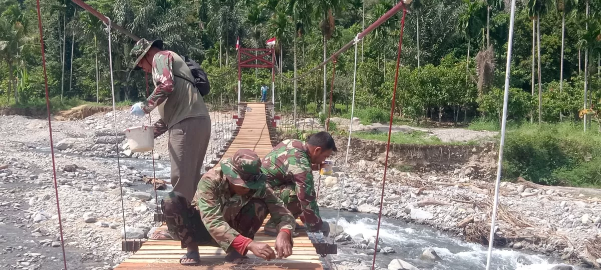 Personel Babinsa Posramil Lawe Sumur kini mempercepat pengerjaan Jembatan Gantung Perintis di Desa Teger Miko, Kecamatan Lawe Sumur, Kabupaten Aceh Tenggara. (Ist)