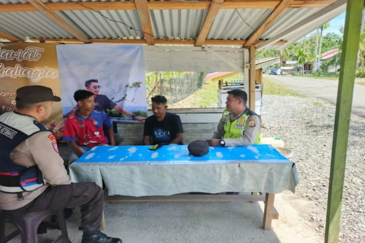 personel Polsek Sungai Mas melaksanakan patroli dialogis dengan menyambangi para pemuda yang sedang berkumpul di salah satu warung kopi di Gampong Kajeung, Kecamatan Sungai Mas, Kabupaten Aceh Barat. (Dok. Polres Aceh Barat)