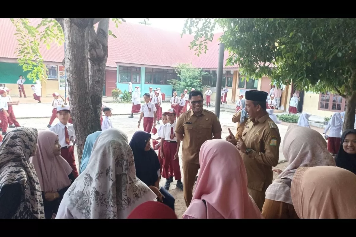 Kasatpol PP dan WH Aceh Besar Muhajir SSTP MPA, dan Camat Kuta Baro Zahrul Fuadi SE MM, berdialog dengan para orang tua peserta didik baru di SDN Leupung 26 Kabupaten Aceh Besar, Senin (13/7/2026). (Dok. MC Aceh Besar)