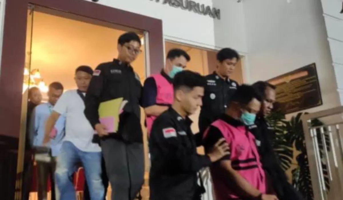 Foto: Tiga tersangka kasus dugaan pungli Program PTSL di Desa Wonosari digiring petugas menuju mobil tahanan usai ditetapkan dan ditahan Kejari Kabupaten Pasuruan.
