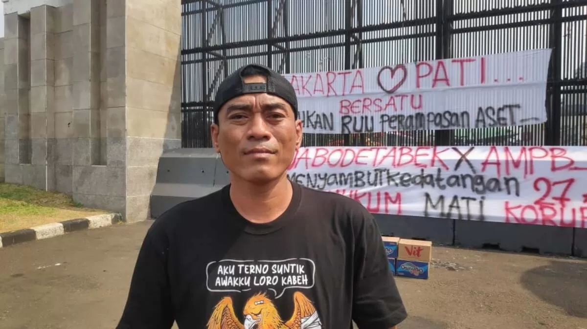 Supriyono alias Botok, Koordinator Aliansi Masyarakat Pati Bersatu (AMPB), berdiri di depan Gedung DPR RI, Jakarta, Jumat (21/8/2026). (Foto: Suara.com/Bagaskara)