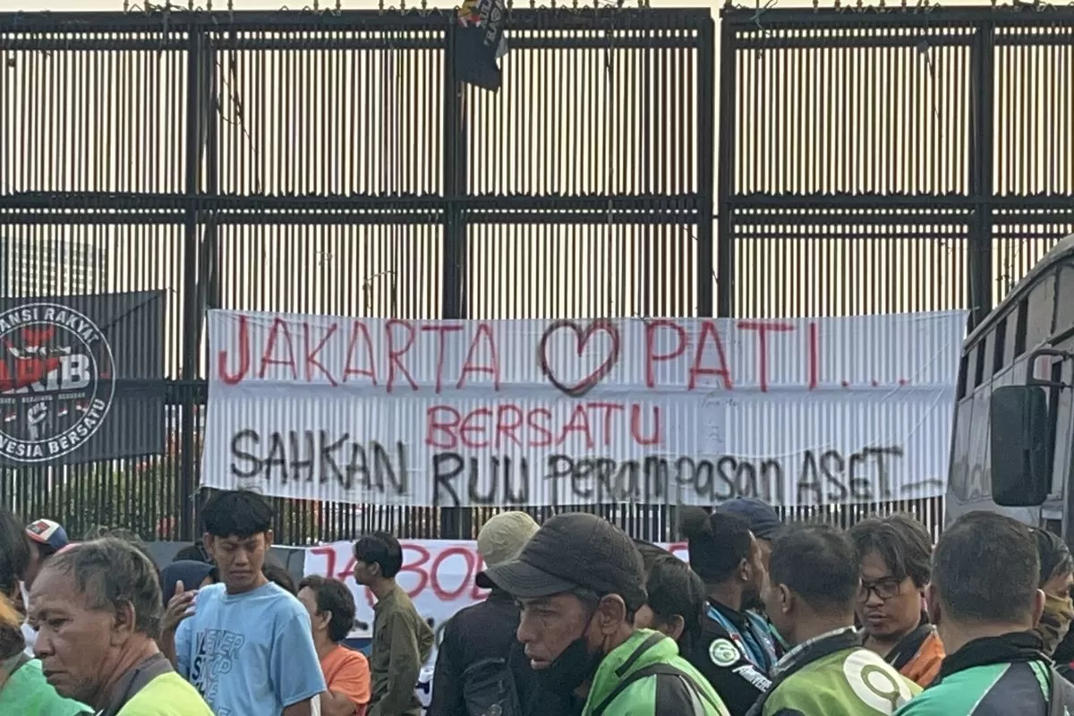 Suasana di depan Gedung DPR RI, Jakarta Pusat, terlihat spanduk "Jakarta Pati Bersatu, Sahkan RUU Perampasan Aset" membentang di pagar gedung perwakilan rakyat, Jumat (21/8/2026). (Foto: Kompas/Pandi Ramedhan)