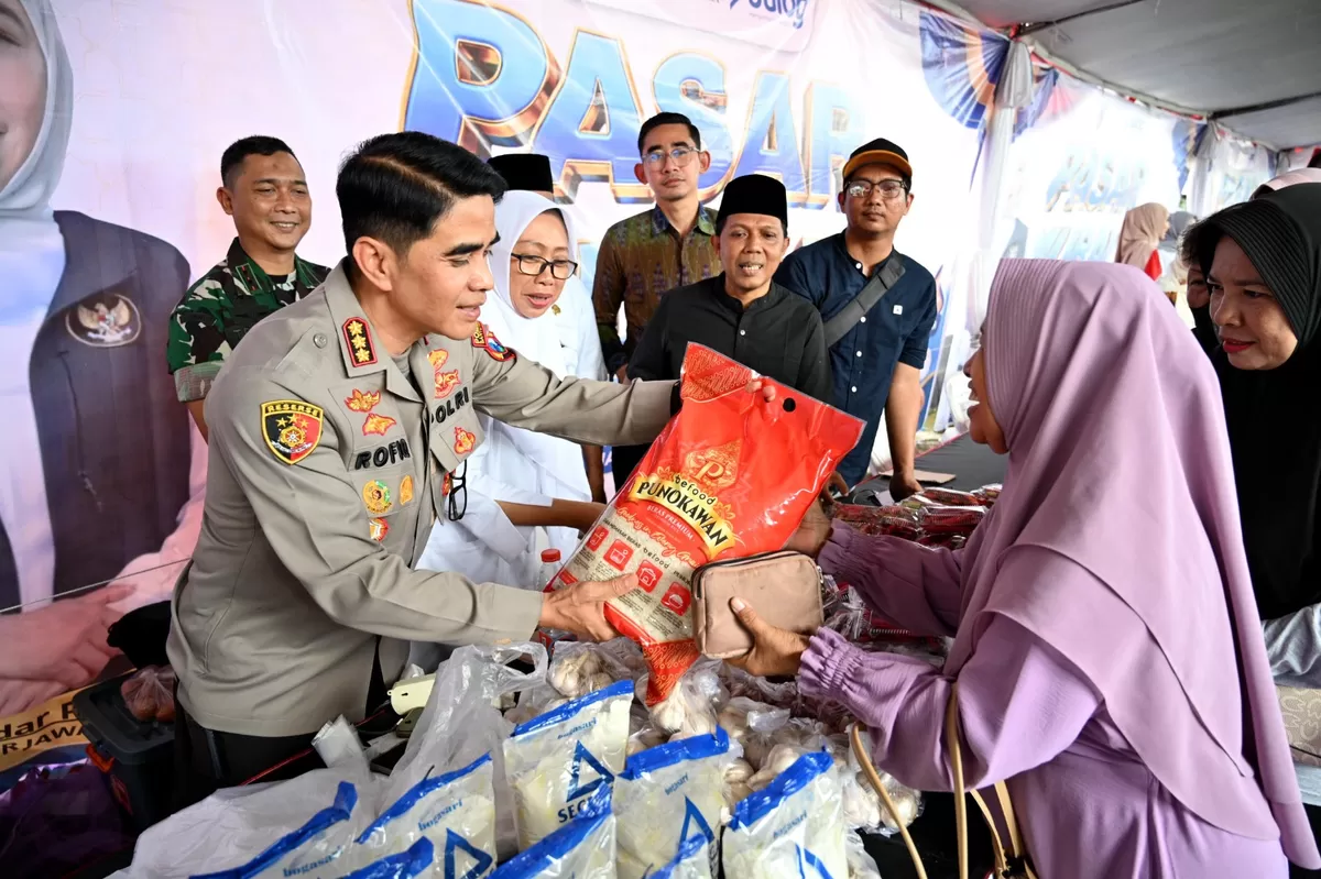 Kapolresta Kombespol Rofiq Ripto Himawan didampingi Imam Maskun, Dandim, dan Kadiskop-UMP menyerahkan beras kepada warga di arena pasar murah KMP Tukangkayu, 