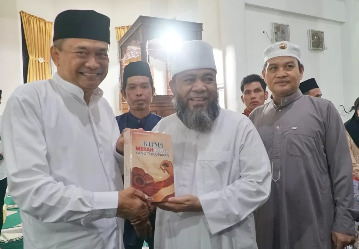 Gubernur Bengkulu, Helmi Hasan serahkan buku Merah Putih kepada Bupati Bengkulu Tengah, Rachmat Riyanto (kiri) pada acara Safari Ramadan Pemprov Bengkulu di Kecamatan Tabah Penanjung.(Foto/Ist)