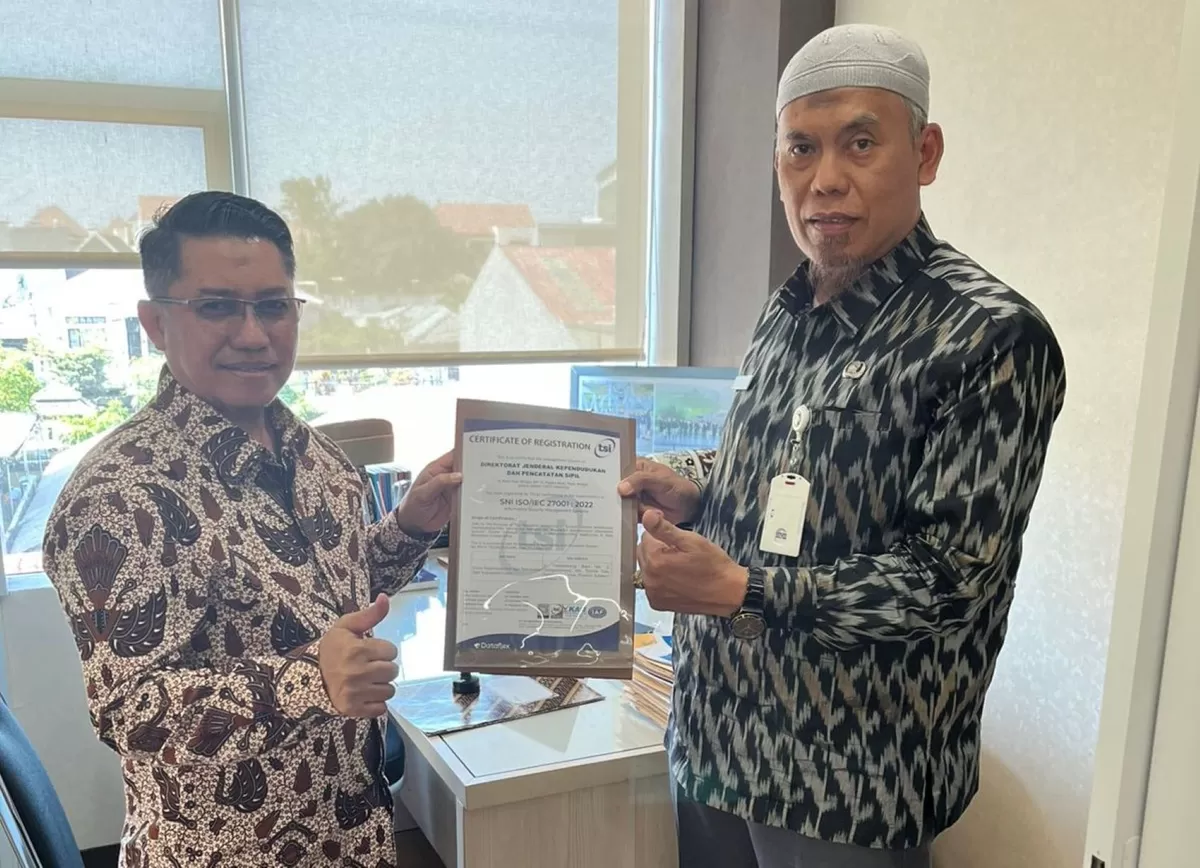 Kepala Dinas Kependudukan dan Pencatatan Sipil Kabupaten Gowa, Edy Sucipto (kiri) dan sertifikasi ISO/IEC 27001:2013 tentang Information Security Management System (ISMS), Senin (6/4). (Ist)