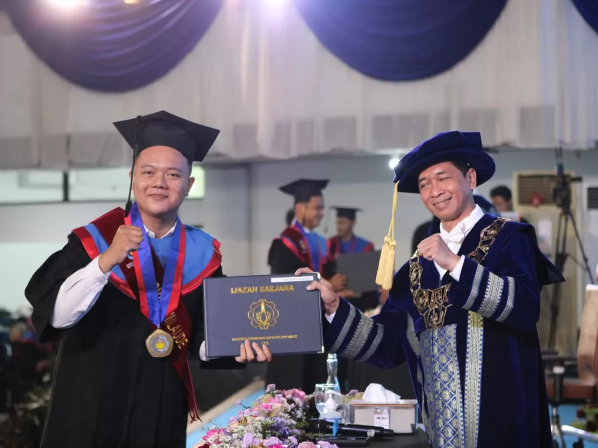 Wisudawan termuda pada Wisuda ke-133 ITS Rochman Sugiarto (kiri) saat menerima ijazah dari Rektor ITS Prof Dr (HC) Ir Bambang Pramujati ST MScEng PhD. (Ist)