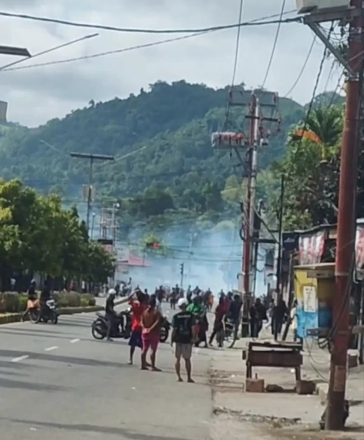 Polisi membubarkan massa dengan gas air mata. 