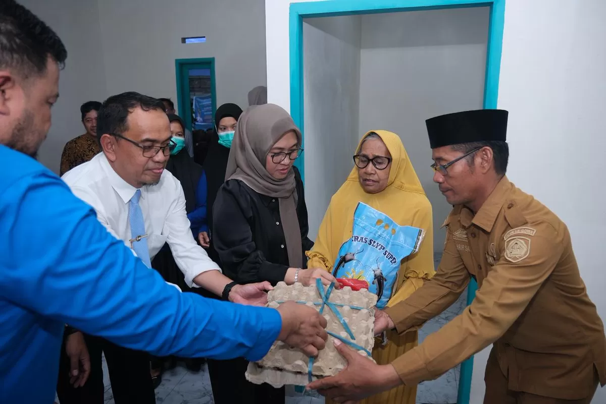 Bupati Gowa, Sitti Husniah Talenrang menyerahkan bantuan sembako usai meresmikan bedah rumah Keluarga Miskin Ekstrem (KME) hasil kerja sama dengan Bank Syariah Indonesia (BSI) kepada KME Zubaedah.(Ist