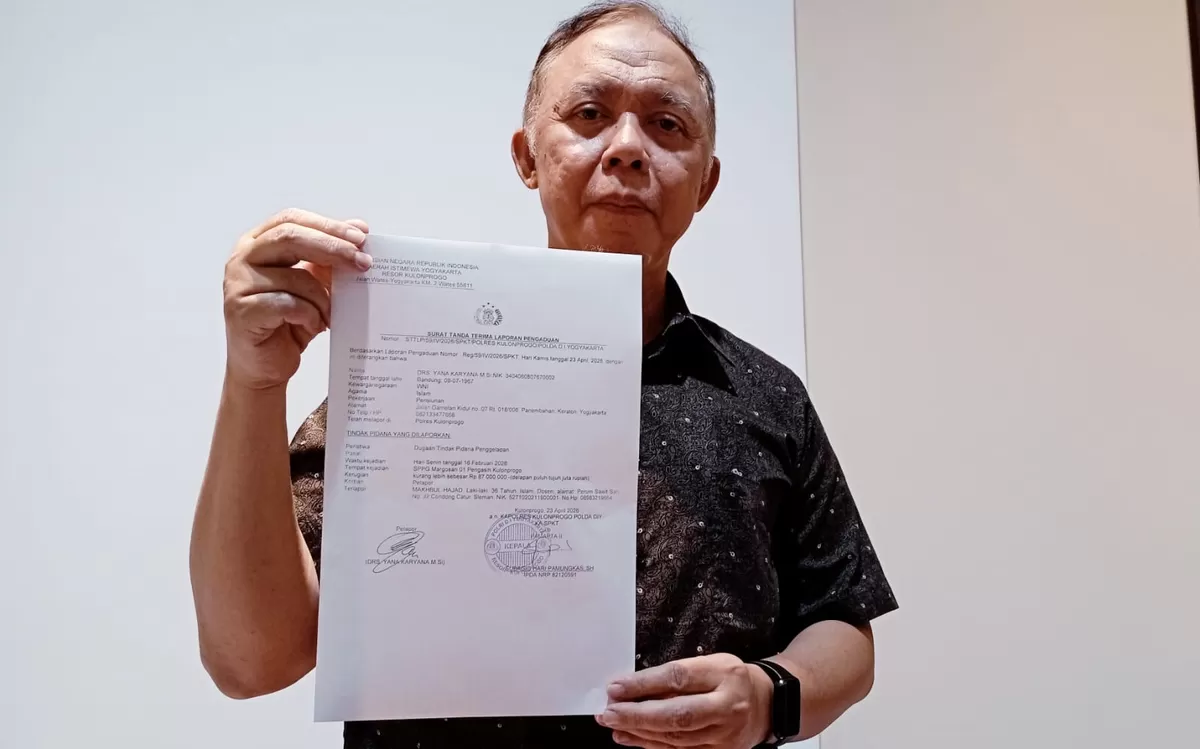 Drs. Yana Karyana dengan bukti Laporan Polisi