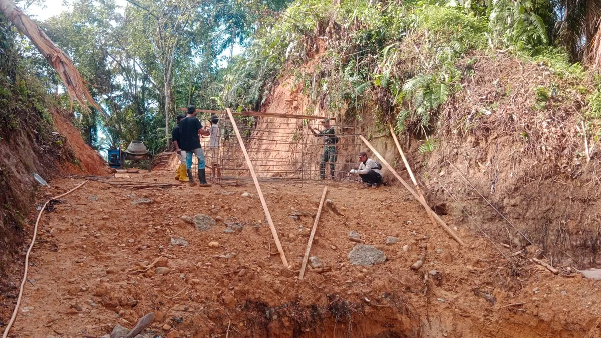 Anggota Babinsa 423-03 Lais, Kodim 0423 Bengkulu Utara melakukan pemdampingan pembagunan jembatang gantung Pagaruyung, agar pekerjaan dapat diselesaikan sesuai target.(Foto/Ist)  