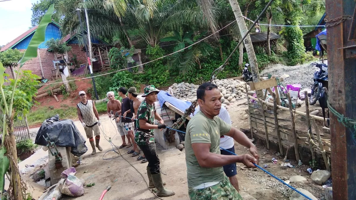 Babinsa Karamil Lais mendampingi percepatan pembangunan jembatan gantung perintis di Desa Pagaruyung, Kabupaten Bengkulu Utara, sehingga dapat diselesaikan sesuai target.(Foto/Ist) 