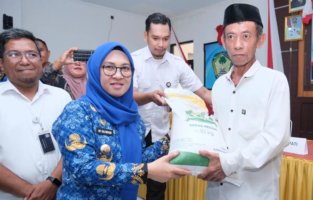 Bupati Gowa, Sitti Husniah Talenrang menyerahkan bantuan pangan kepada salah seorang warga penerima manfaat di Aula Kantor Camat Pallangga, Gowa, Rabu (20/5). (Ist)