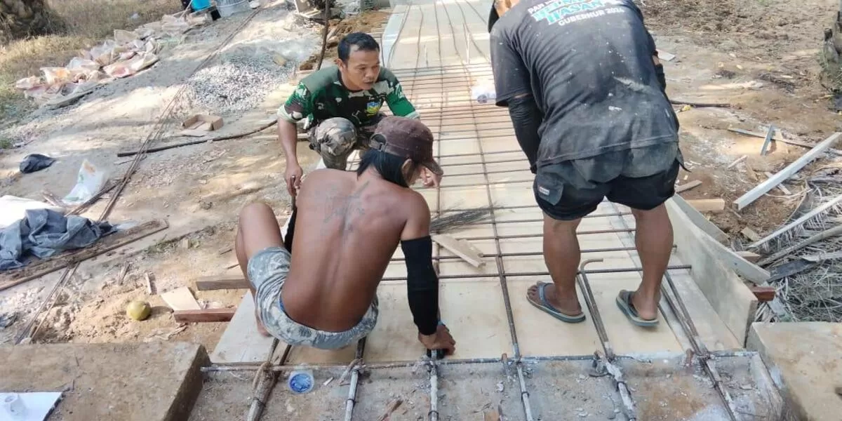 Anggota Babinsa Lais, Kodim Bengkulu Utara melakukan pengawalan dan pengawasan terhadap pelaksanaan pembangunan jembatan gantung Garuda di Desa Pagaruyung, Bengkulu Utara.(Foto/Ist)
