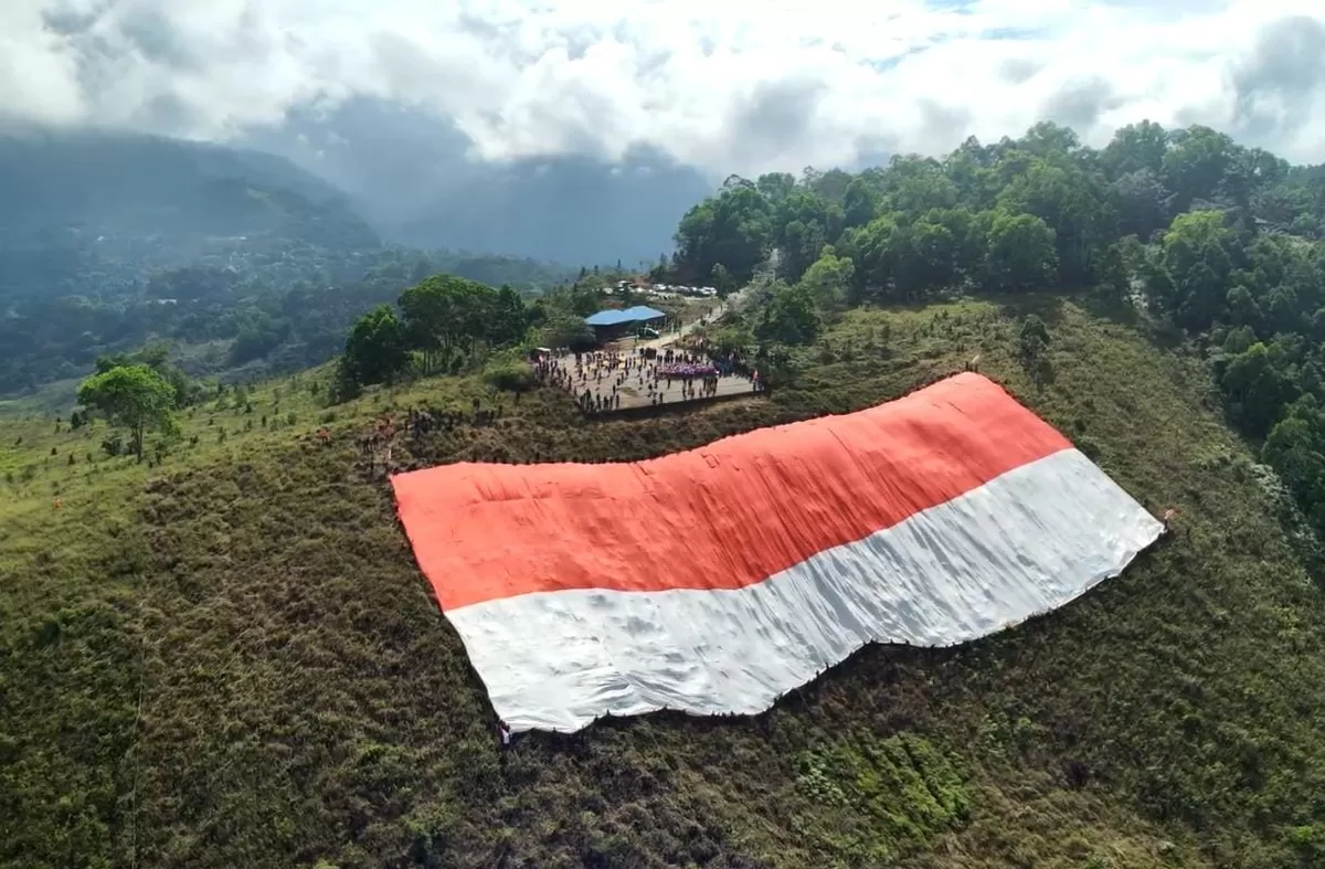 Bendera Merah Putih berukuran kolosal 120 x 80 meter terbentang luas di atas lereng bukit (Istimewa)