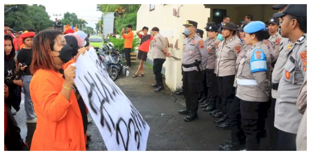 Massa PMKRI dan GMNI berhadapan dengan barikade pengamanan polisi di gerbang Mapolres Sikka saat aksi demonstrasi berlangsung di tengah hujan deras. (Foto TBN Polres Sikka)