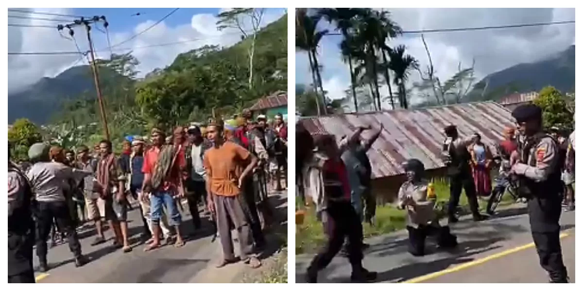 Seorang anggota polisi berlutut di tengah dua kelompok warga bersenjata saat ketegangan perang tanding di Desa Bula, Manggarai, Senin (16/3/2026). (Foto ist.)