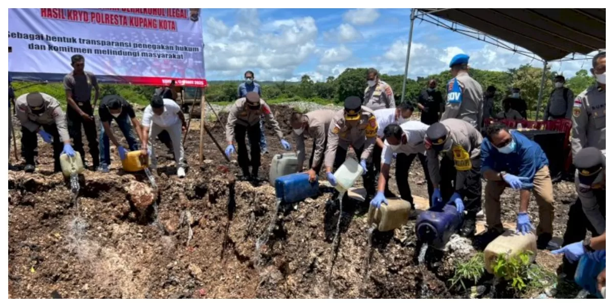 Petugas Polresta Kupang Kota memusnahkan ribuan liter miras ilegal di TPA Alak dengan cara ditumpahkan ke lubang tanah dalam kegiatan terbuka. (Foto TBN Polresta Kupang Kota)