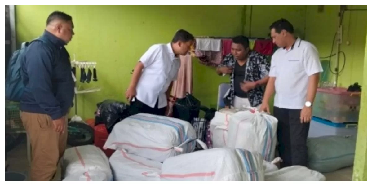 Petugas kepolisian menunjukkan barang bukti ballpress pakaian bekas impor hasil penyitaan di wilayah perbatasan Kabupaten Belu dalam operasi pengungkapan kasus penyelundupan. (Foto TBN Polda NTT)