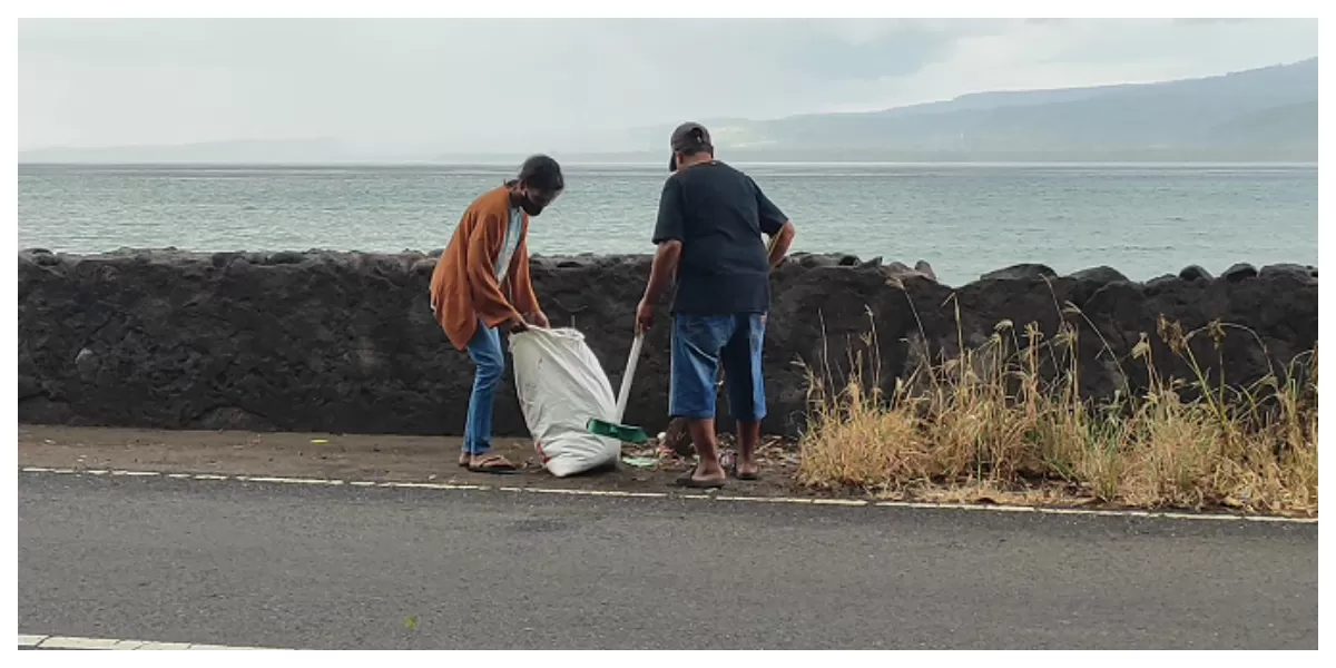 Petugas DLH Flores Timur membersihkan sampah liar yang berserakan di sepanjang jalur pintu masuk Kota Larantuka saat kerja bakti, Sabtu (20/6/2026). (Foto Ist)