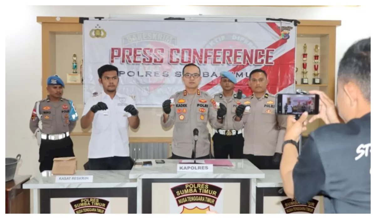 Kapolres Sumba Timur I Kadek Hery Cahyadi memperlihatkan barang bukti serbuk emas dan telepon genggam saat konferensi pers di Mapolres Waingapu. (Foto Polda NTT)