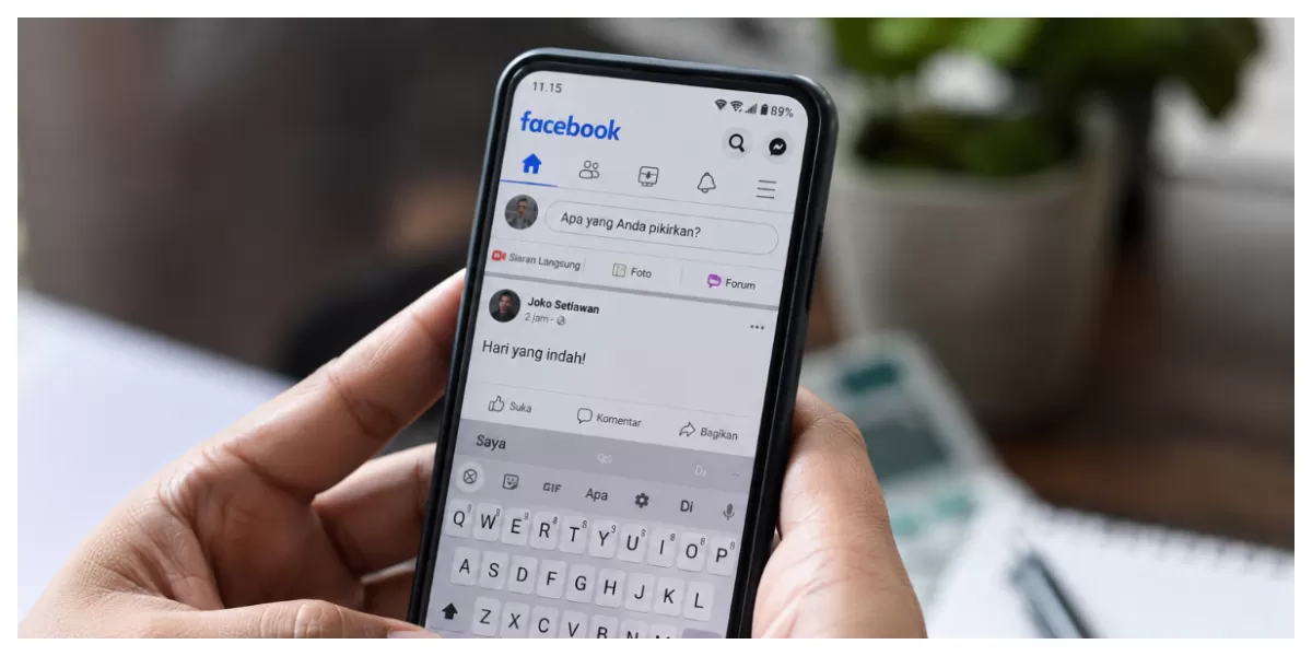 Ilustrasi seorang pengguna sedang mengetik di aplikasi Facebook melalui telepon genggam. Aktivitas di media sosial menjadi bagian dari ruang digital yang tetap diatur oleh ketentuan hukum . ( FOTO/ILUSTRASI/ AI)
