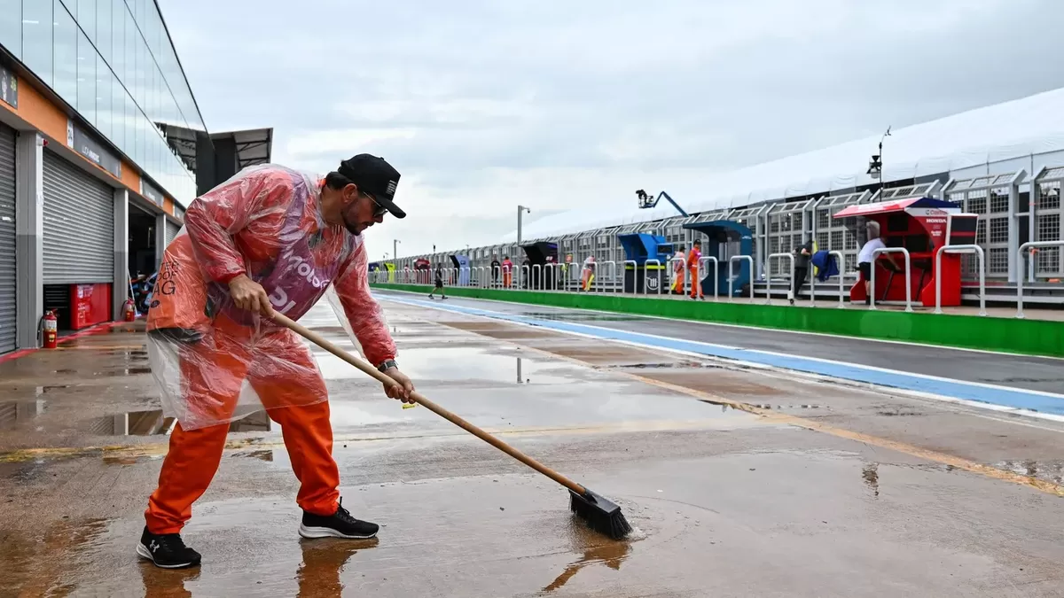 Seorang kru terlihat membersihkan paddock dari genangan air (MotoGP)