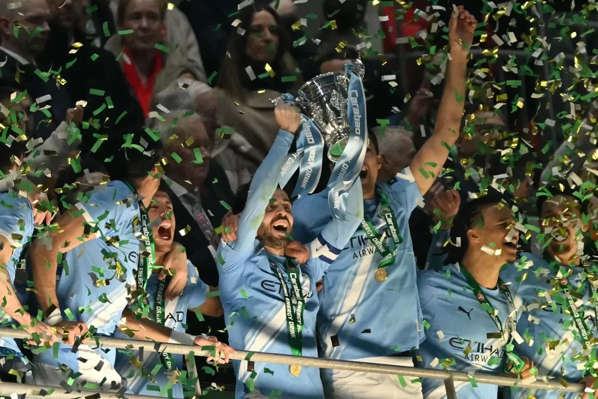 Para pemain Manchester City mengangkat tinggi trofi juara Piala Carabao.