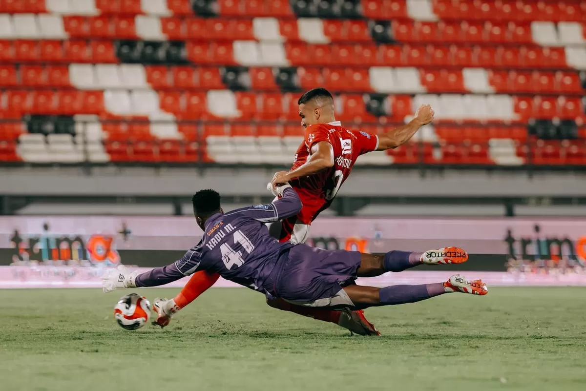 Striker Balu United Boris Kopitovic berduel dengan kiper PSBS Biak, Kadu. (Bali United FC)