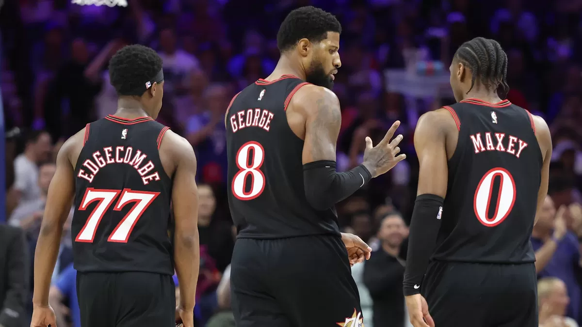 Penyerang 76ers Paul George (8) berbincang dengan guard Tyrese Maxey (0) dan guard Vj Edgecombe (77) saat jeda pertandingan melawan Orlando Magic pada kuarter ketiga babak play-in NBA Playoffs 2026. (Imagn Images )