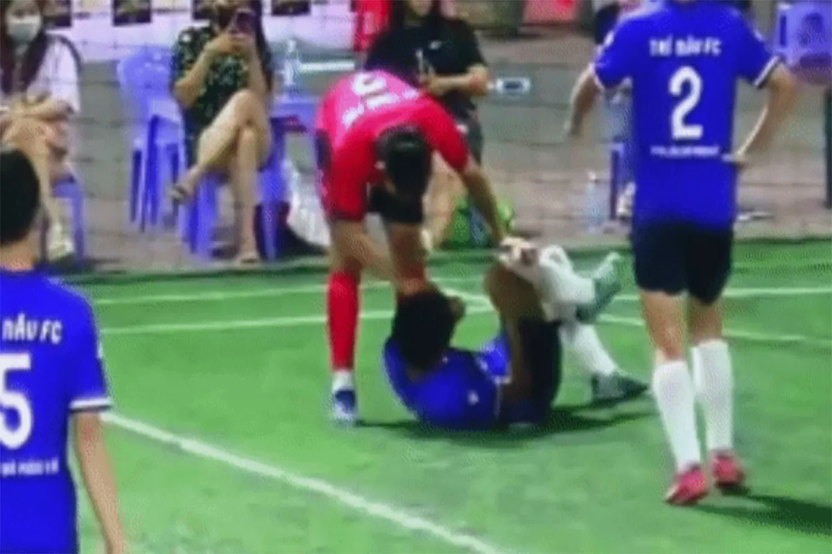 Pemain D.VT dari tim "Tung Pho" menendang kepala pemain dari tim "Tri Nau". 