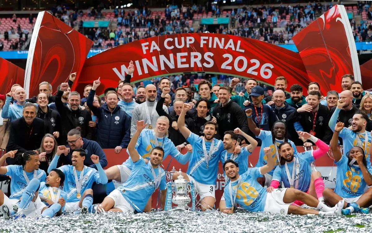 Para pemain dan staf Manchester City merayakan dengan trofi Piala FA setelah mengalahkan Chelsea.